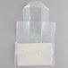 A clear plastic bag with a clear plastic bag inside with white handles.