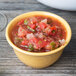 A bowl of salsa in a GET Diamond Mardi Gras Tropical Yellow melamine bowl on a wood surface.