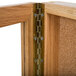 A close-up of a wooden cabinet with a gold door hinge.
