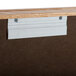 A wooden display case with metal clips on it.