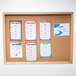 An Aarco enclosed cork bulletin board with menus on it.