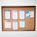 An Aarco walnut enclosed bulletin board displaying menus.