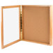 An Aarco natural oak enclosed hinged bulletin board with a cork board.