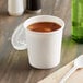 A white paper cup with a vented plastic lid on a counter.