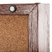 A cork bulletin board with a walnut frame and a screw in the corner.