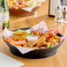 A black plastic diner platter filled with chicken wings and vegetables.