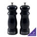 A black salt and pepper mill set with white lids on a counter.