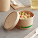 An EcoChoice Kraft paper food container filled with rice and vegetables with a vented lid.