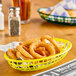 A yellow plastic fast food basket filled with fried onion rings.