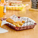A brown rectangular plastic fast food basket filled with food on a table.