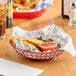 A Choice round brown plastic fast food basket with fries and red sauce on a table.