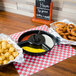 A black container with a tray of food and a sign on a table.