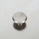 A stainless steel Vollrath knob on a metal surface.
