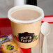 A tray with a Choice paper soup cup of hot food and a vented plastic lid with a spoon on it.