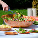 A person cutting salad in a Thunder Group woven wood bowl.