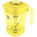 A yellow Waring blender jar with a handle.