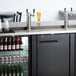 An Avantco black kegerator with beer on tap.