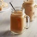 Two glass mugs of coffee with DaVinci Gourmet French Vanilla syrup in a glass jar with a straw.