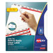 A hand using an Avery Big Tab label divider set to label a blue divider with a pencil.