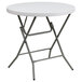 A Flash Furniture round white plastic folding table with metal legs.