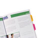 A close-up of a manual of financial services with yellow, pink, and green Avery Ultra Tabs.