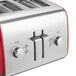 A red and silver KitchenAid four slice toaster on a counter.