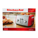 A KitchenAid Empire Red toaster with bread inside.