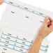 A hand holding an Avery file folder with clear labels.