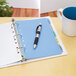 A pen on Avery multi-color plastic dividers in a notebook.