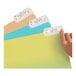 A hand using Avery Removable White File Folder Labels on a file folder.