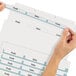 A person using an Avery Index Maker divider to label a file folder.