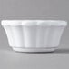 A white Carlisle scalloped ramekin on a gray surface.