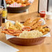 A Choice 12" brown plastic diner platter with food on a table.