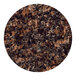 A round tan brown granite tabletop with black and brown speckles.