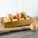 A Tablecraft acacia wood crate filled with apples on a table.