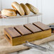 A person holding a Tablecraft acacia wood serving crate with bread.