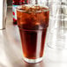 An Anchor Hocking Stackable Cooler Glass filled with iced tea on a white background.