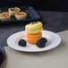 A Villeroy & Boch white porcelain flat plate with three macarons and blackberries on it.