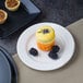 A white Villeroy & Boch porcelain flat plate with a dessert, blackberries, and a yellow macaroon.