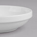 A Villeroy & Boch white porcelain bowl with a rim on a gray surface.