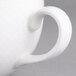 A close-up of a Villeroy & Boch white porcelain cup with a handle.