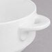 A close up of a Villeroy & Boch white porcelain soup cup with a handle.