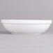 A white Villeroy & Boch porcelain salad bowl on a gray surface.
