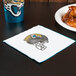 A Jacksonville Jaguars luncheon napkin with a football helmet logo on it next to a plate of chicken wings.