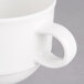 A close-up of a Villeroy & Boch white porcelain coffee cup with a handle.