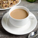 A Villeroy & Boch white porcelain cup of coffee on a plate with pastries.