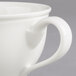 A close-up of a Villeroy & Boch white porcelain cup with a handle.