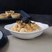 A Villeroy & Boch white porcelain square salad bowl filled with food on a table.