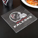 A Creative Converting Atlanta Falcons luncheon napkin with a black and red Falcons logo on it.