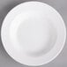 A white Villeroy & Boch porcelain rim deep soup plate on a gray surface.